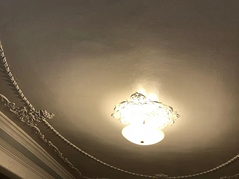 Photo of beautiful ornate original high ceiling in front living room.