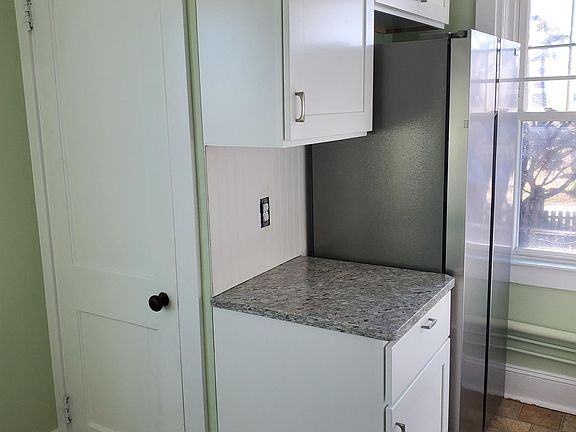 Cabinets and refrigerator. Washer and dryer behind door.