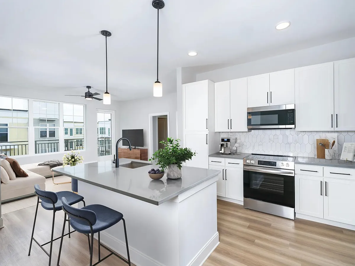 Our alternative option features fresh white cabinets with black hardware, gray quartz counters, and vertical, precious Calacatta Florida tile. - Modera Liberty Row