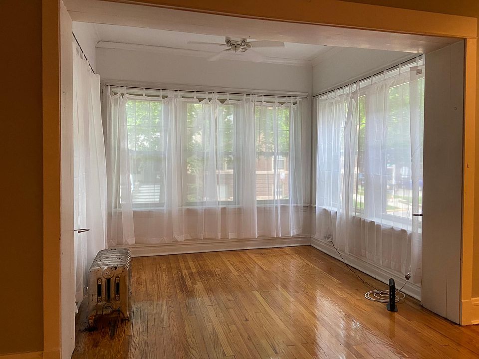 Front sunroom off the living room comes with curtains.