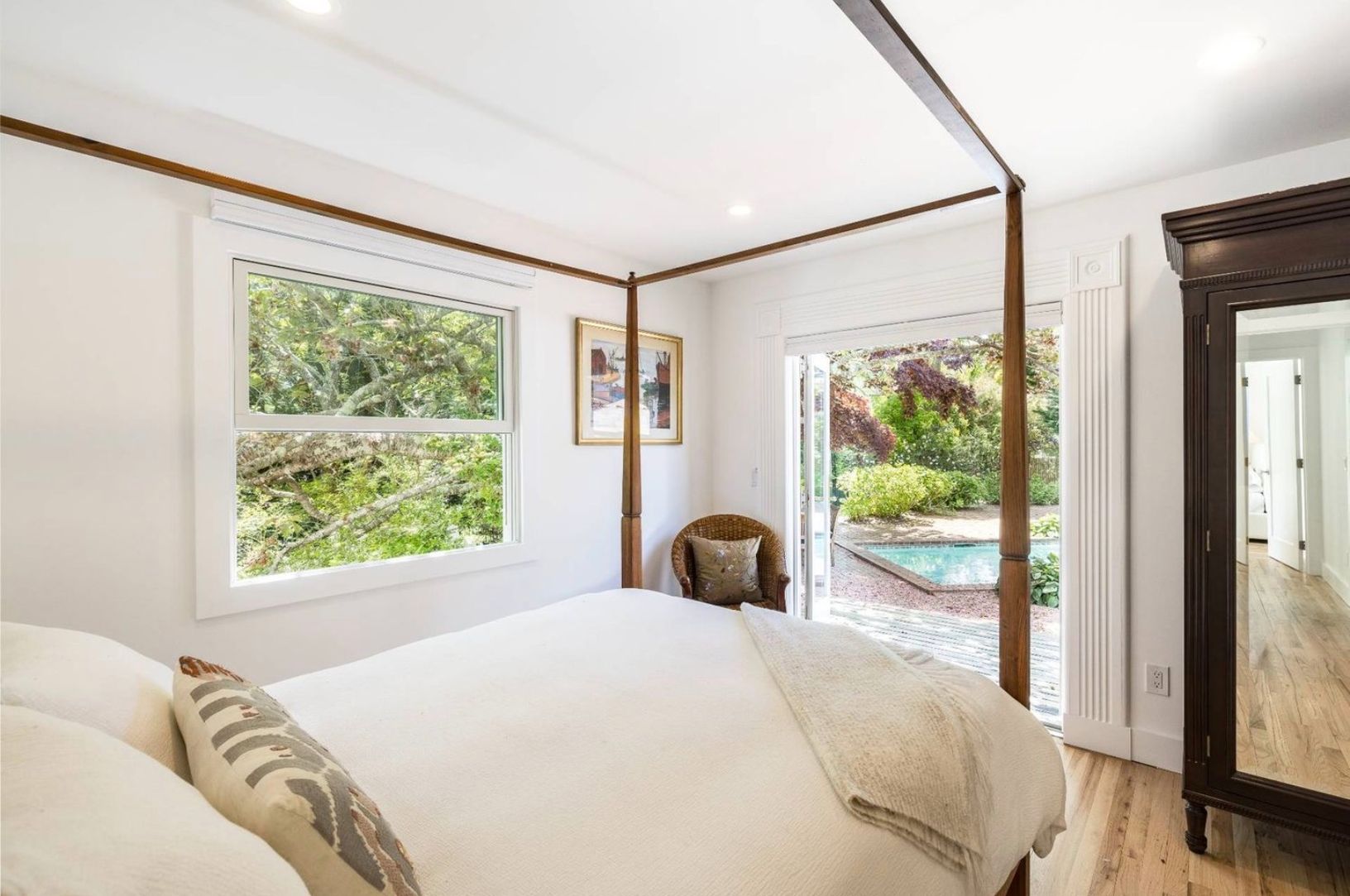  upstairs bedroom with queen bed, doors open to pool area