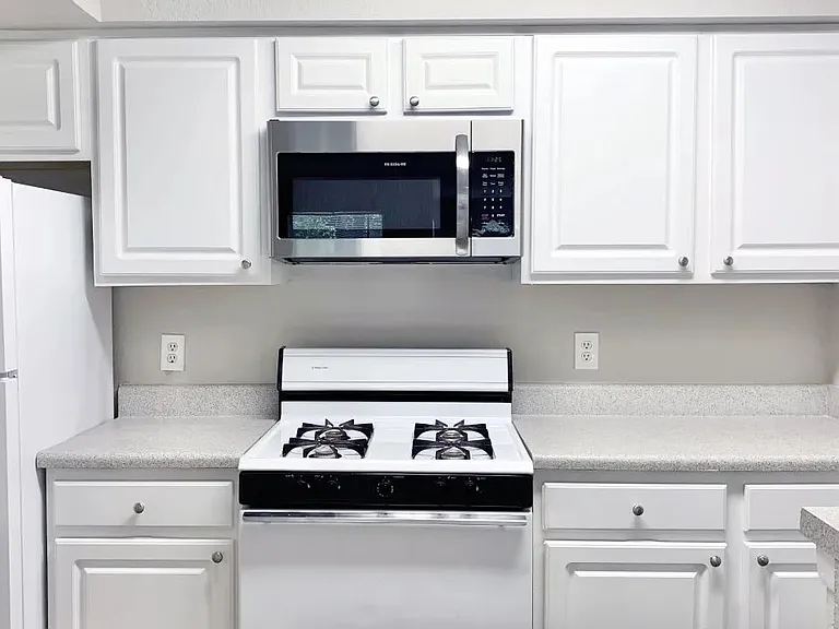 Bright and functional, this kitchen includes classic cabinetry, and durable countertops, and a breakfast bar.