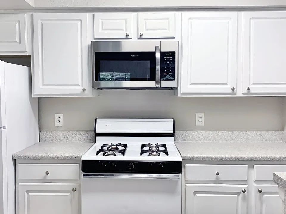Bright and functional, this kitchen includes classic cabinetry, and durable countertops, and a breakfast bar.
