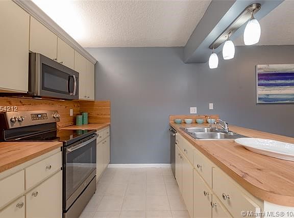 KITCHEN OFFERS PLENTY OF STORAGE COUNTER SPACE & DOUBLE SINKS