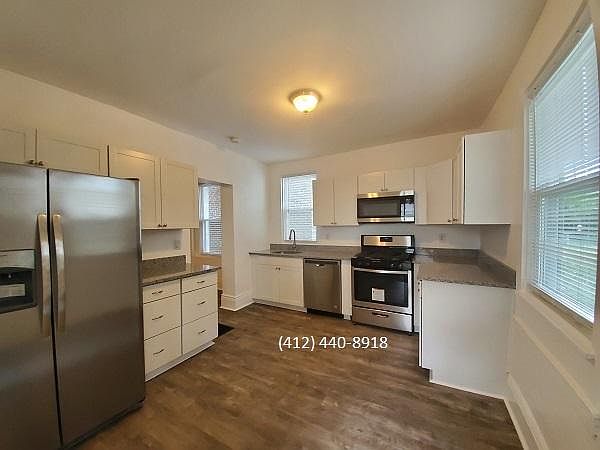 Large kitchen with new stainless steel appliances and quartz counters