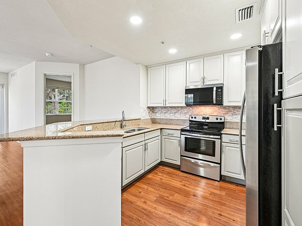 Remodeled kitchens with granite countertops, sleek stainless steel appliances, and elegant cabinetry, all complemented by beautiful hardwood flooring and a spacious open layout.