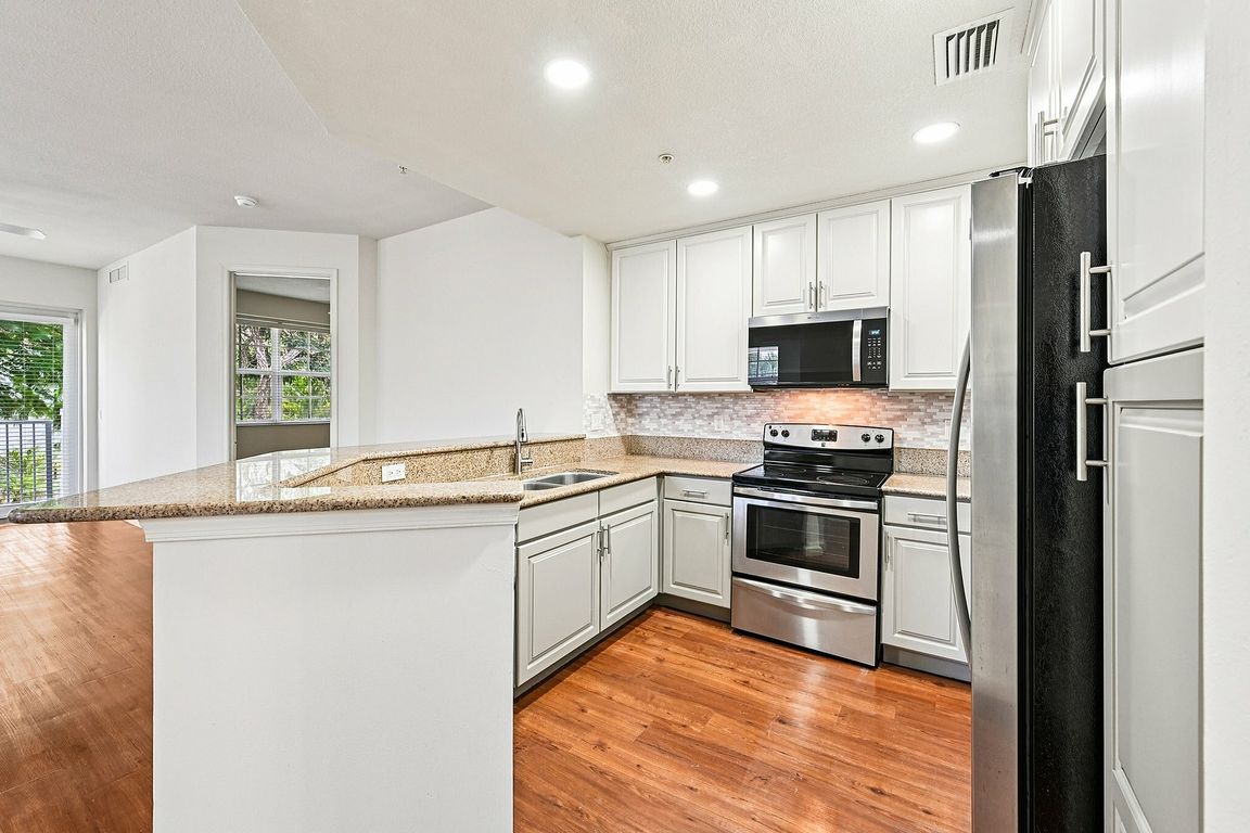 Remodeled kitchens with granite countertops, sleek stainless steel appliances, and elegant cabinetry, all complemented by beautiful hardwood flooring and a spacious open layout.