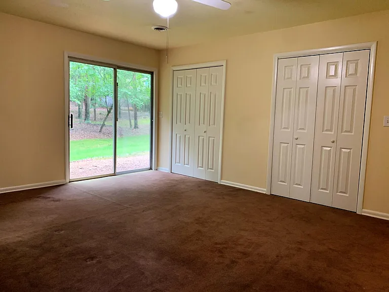 Master bedroom with private entryway and two large closets. Note: carpeting was recently replaced with waterproof laminate flooring. Updated photos to follow.