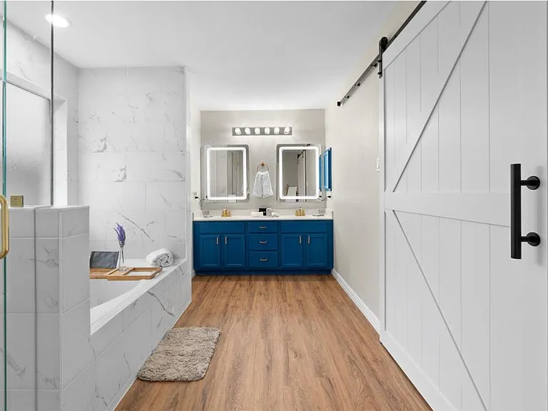 Master en-suite. 2 sinks, Jacuzzi tub, separate walk-in shower, separate toilet. Barn doors to your right lead you to a hidden dressing room with a vanity.