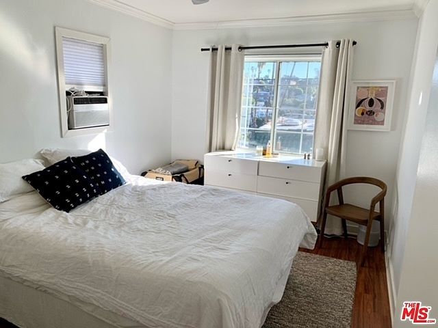 Bedroom with window AC and plenty of natural light.