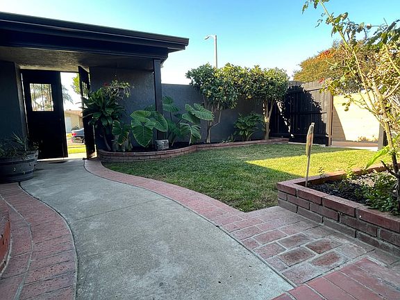 Beautiful Curb Appeal with Fresh Exterior Paint, Tropical Landscaping With Fruit Trees and courtyard