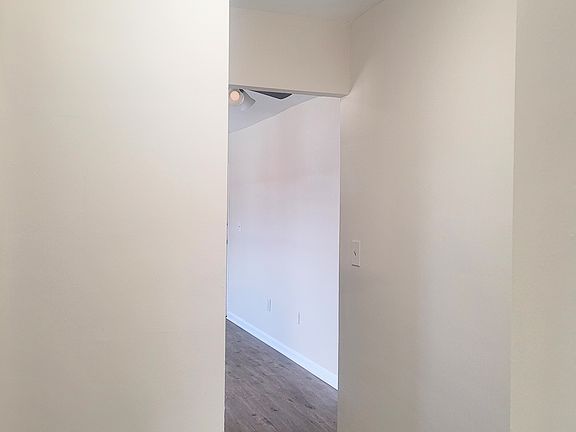 Hallway separates living area from bathroom and bedroom.