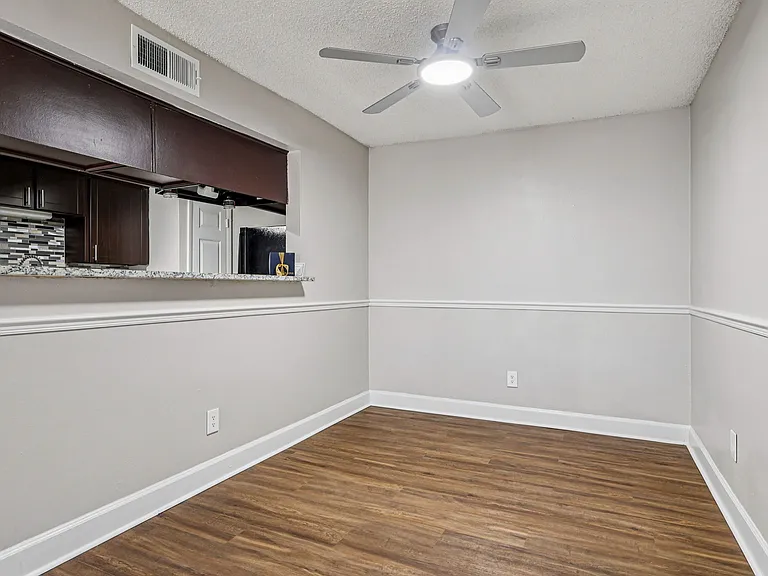 Open dining space featuring a kitchen pass-through and wood-style flooring.