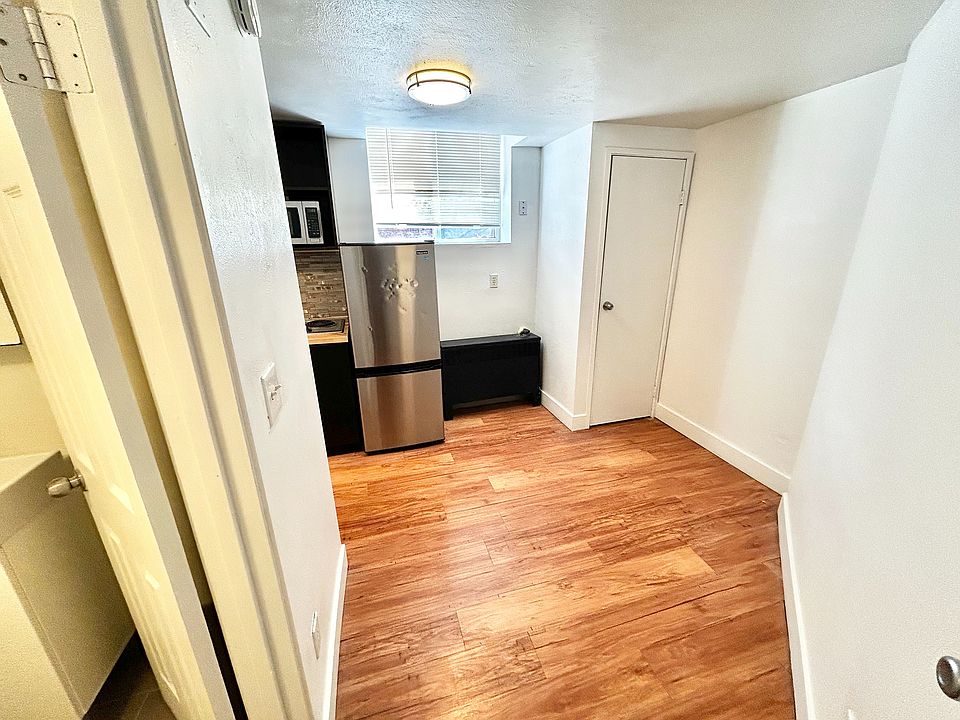 Inviting kitchen space with sleek stainless steel appliances, abundant natural light, and elegant wood flooring.