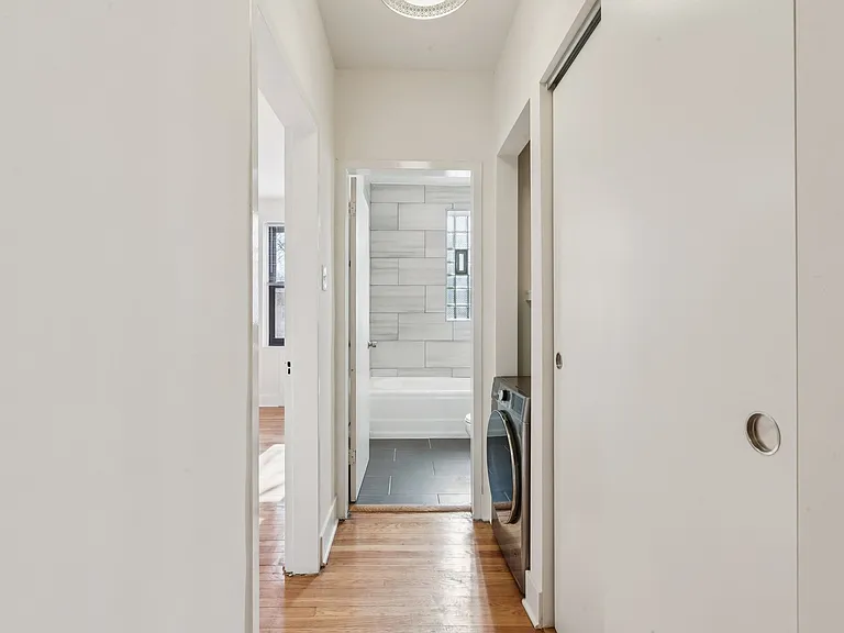 Hallway with in-unit washer/dryer combo and closet