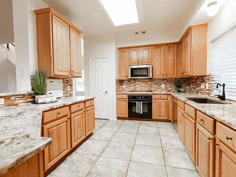 Kitchen with granite countertop, gas cooktop and microwave