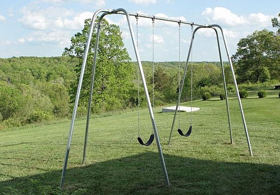 Commercial quality swing set behind house.