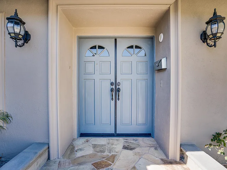 Large entry with double doors and nice porch lights.
