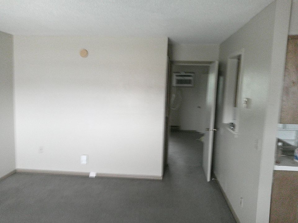 First view of the apartment from the front door showing the view into the bedroom, the kitchen wall on the right