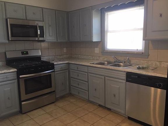 Kitchen with gas stove, dishwasher and built in microwave.