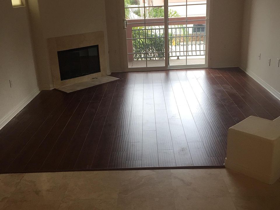 cheerful and comfy lounge and arena halls in open space view with mahogany laminate and natural travertine flooring _ so appealing _