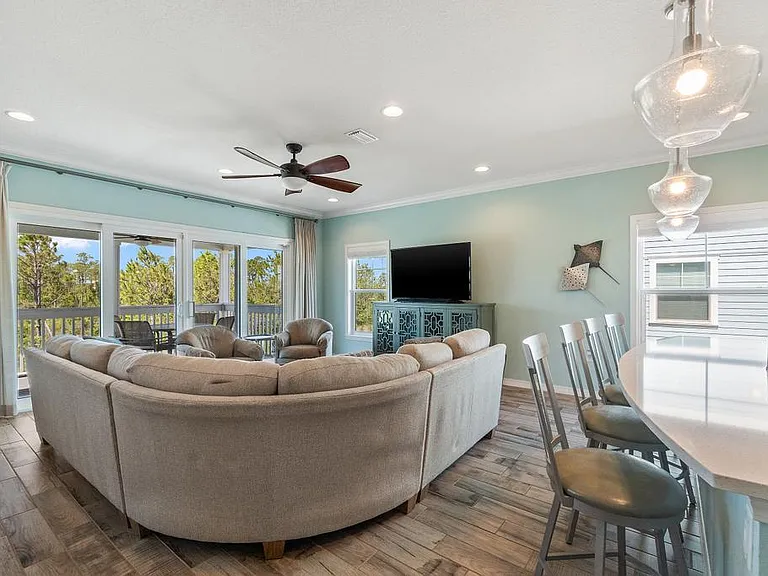 Living room with balcony overlooking golf course & pond.