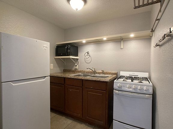 bright kitchen with microwave, gas stove & fridge