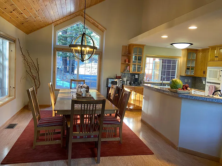 Dining table off of kitchen with bar counter for serving. Table has a leaf and can seat 8-10