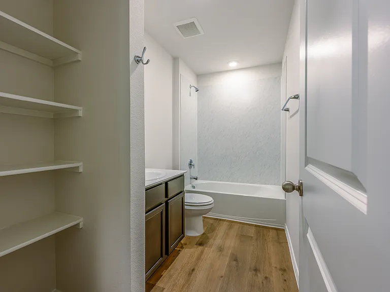 Secondary bathroom with storage shelving