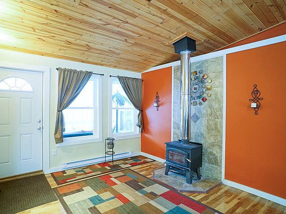 Once inside the home you will be impressesd by the expansive open floor plan that still feels cozy.  This entry sitting area with wood stove serves also as a foyer area.  The wood stove adds ambience as well as off setting other heating costs.