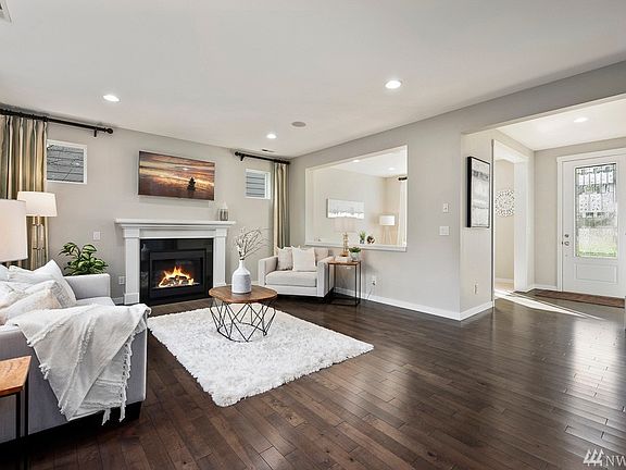 Open living room with a contemporary gas fireplace, silk drapes and designer's touches. A/C, built-in speakers & designer's paint throughout.