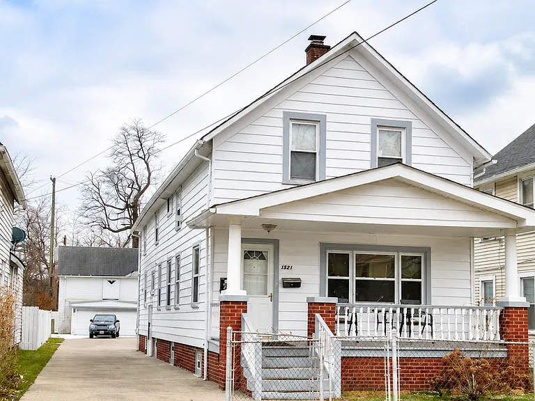 Charming duplex-style home with private upper-unit entry, driveway, front porch, and classic Cleveland character