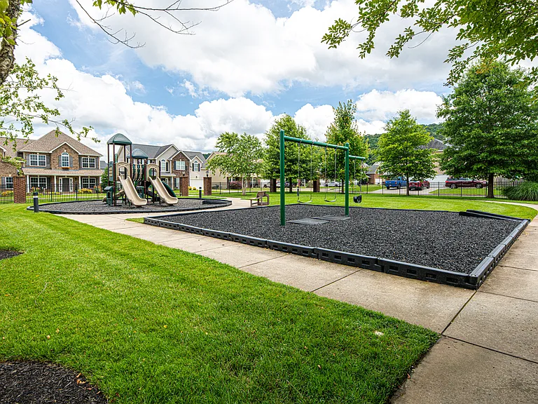 A premier neighborhood gathering space complete with high-end play ground equipment, inclusive swing sets, accessible sidewalk, and relaxing park benches