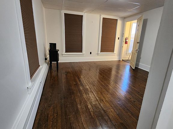 Antique tiger oak wood floors in bedroom and living room.. room darkening custom blinds..