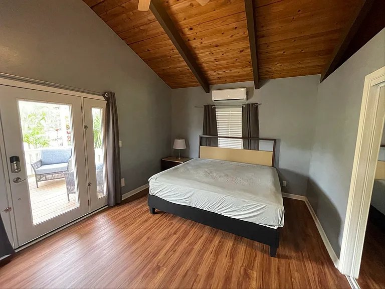 Main bedroom with king bed and door to the front lanai