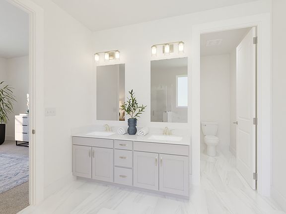 The primary bathroom offers dual vanity sinks and a walk-in shower.