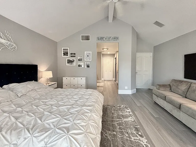Upstairs primary bedroom with king bed and balcony overlooking the lake