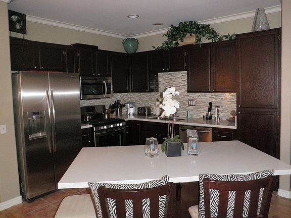 Kitchen which is fully open to the dining area (which would be to the right in this photo). Photo perspective taken from living area which would be across the entire bottom of this photo. The bedrooms are to the far left and far right of this photo (separ