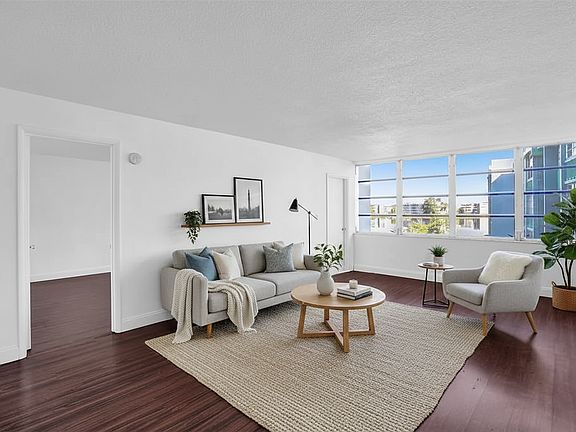 Living Room with large window and lakefront view. Blinds included - not pictured here. (Staging by AI, furniture not included)