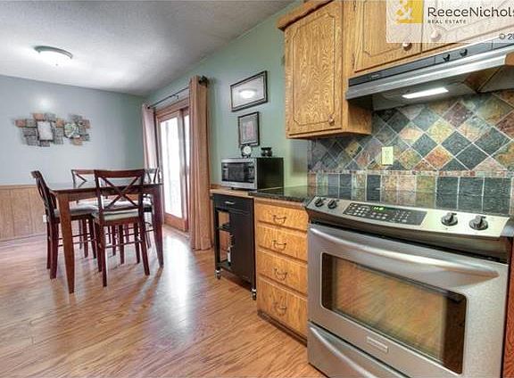 Hardwood floors extend into the kitchen with stainless steel range and updated back splash and counter tops.