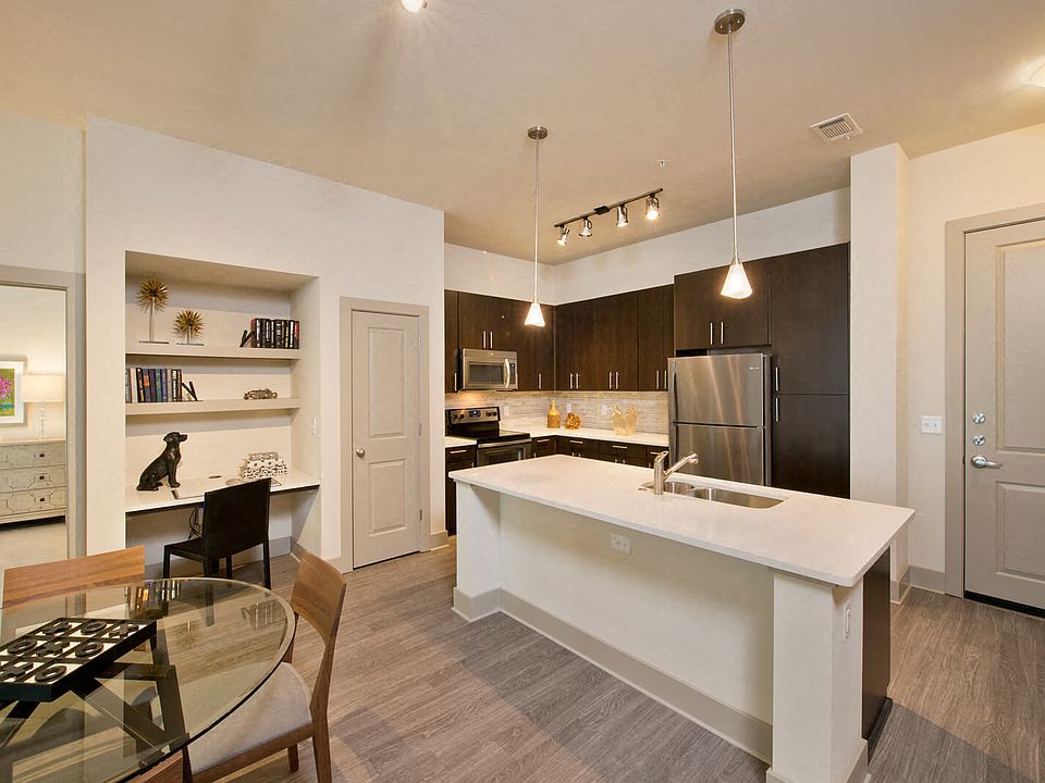 Open-concept gourmet kitchens with stainless steel appliances, granite slab countertops, custom cabinentry, and natural stone backsplash