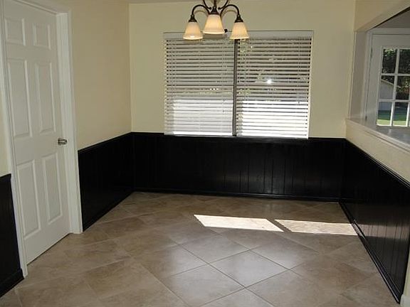 Breakfast area with tile floors and windows overlooking backyard