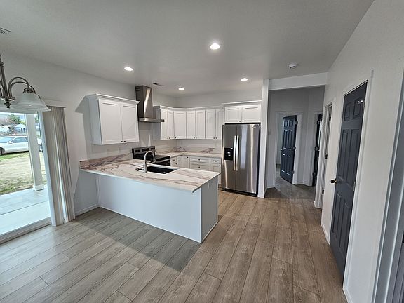 Kitchen with large island. Hard surfaces counter tops and self closing doors and drawers.