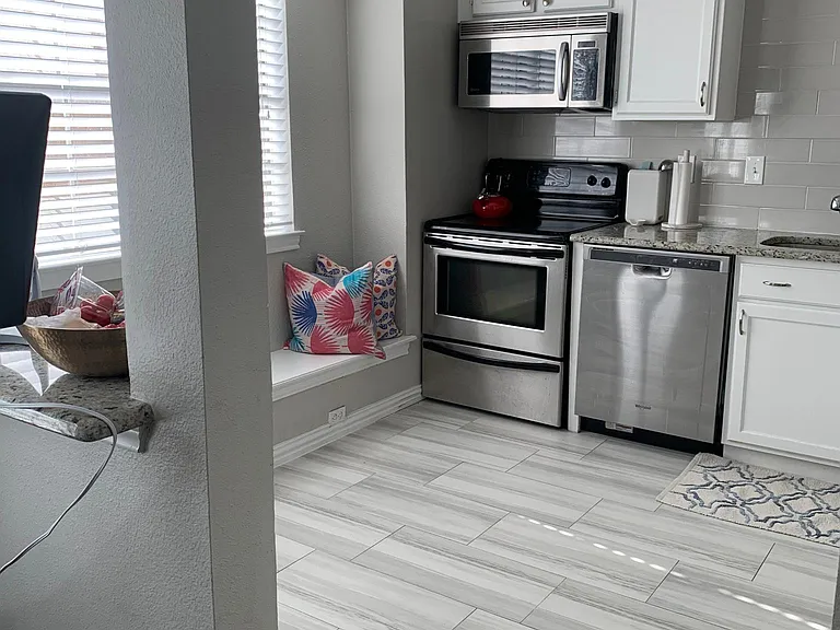 large, updated bright kitchen, with stainless steel appliances and window seat looking out to private patio