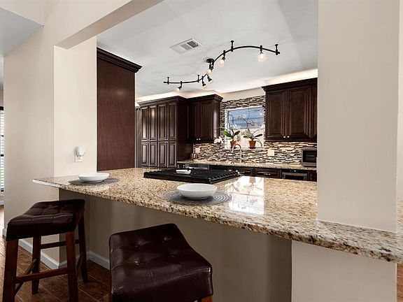 Bridging the space between living and kitchen, this stunning granite counter top island serves as an additional space for entertaining or dining, bringing the open-concept feel to life.