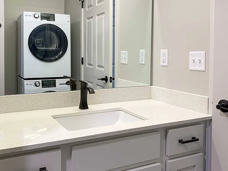 Modern bathrooms include sleek finishes and in-home laundry for added convenience.