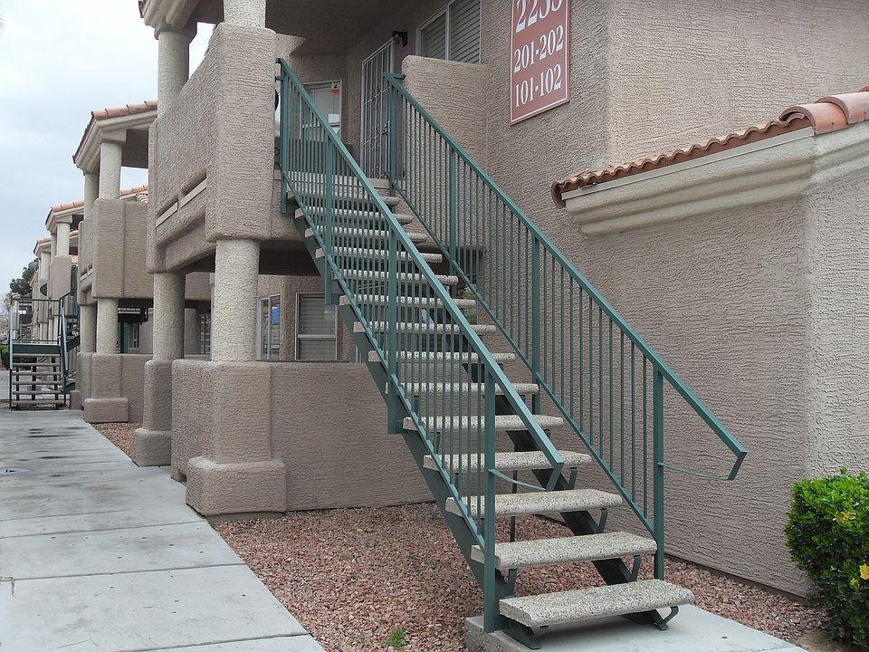 View of building exterior walkway toward rear stairway to unit #201