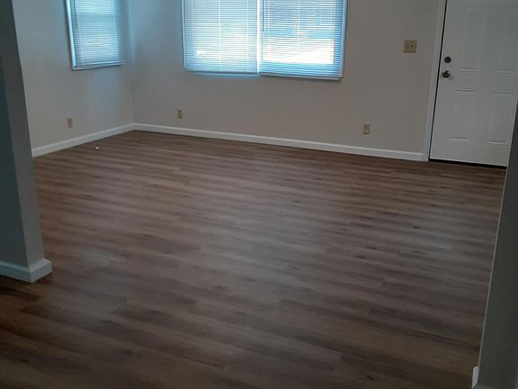 Spacious living room with new waterproof laminate and ceiling fan. New mini blinds