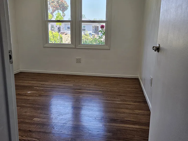 From hall area, looking towards bedroom, highlighting hardwood floors.