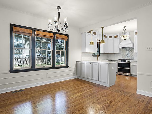 Dining room with large windows, chandelier, and natural light.